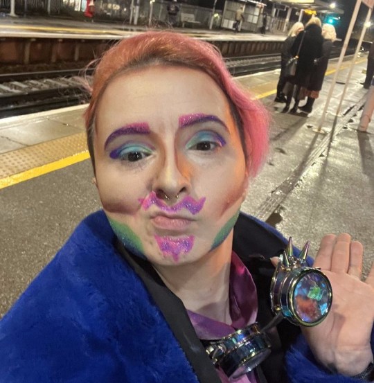 Une personne dans une gare avec un maquillage pailleté