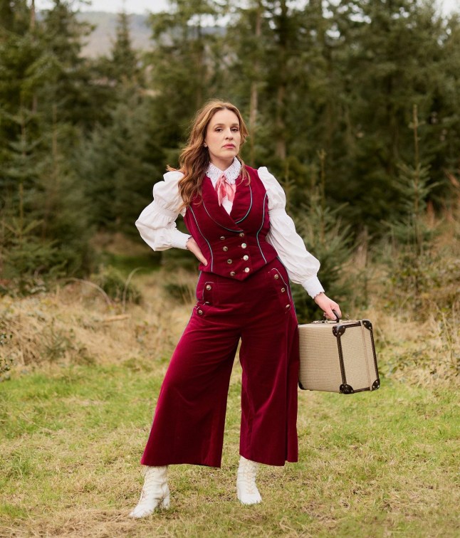 Katie Norris pose tout en tenant une valise