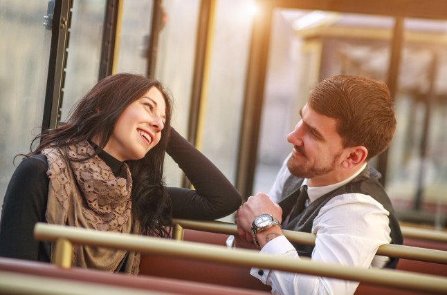 Un jeune homme rencontre et parle à une fille dans une cabine de transport public en tramway