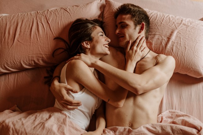 Heureux jeune couple couché dans son lit.