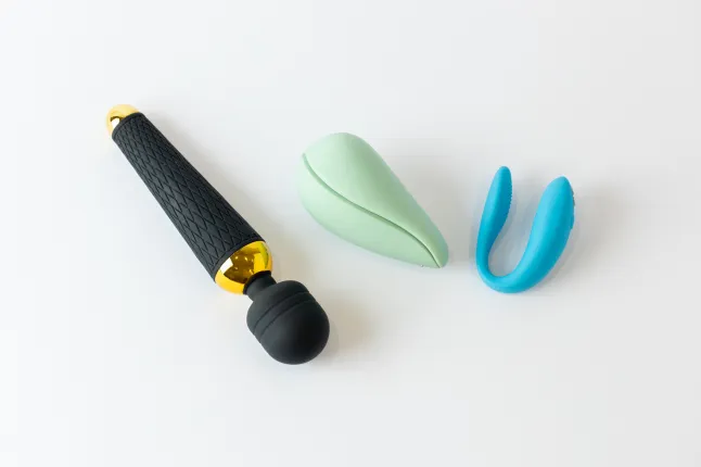 Gros plan sur fond blanc avec trois jouets sexuels sur le dessus, un désir et deux autres vibromasseurs plus petits