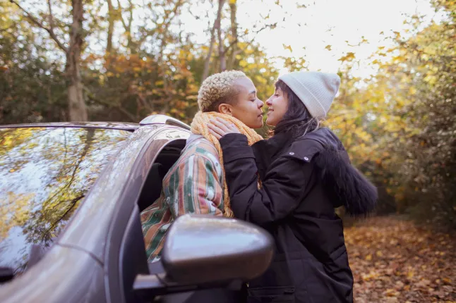 Royaume-Uni, Londres, Richmond, couple lesbien s'embrassant en voiture dans la forêt d'automne