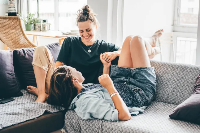 Couple de femmes profitant du temps ensemble sur un canapé.
