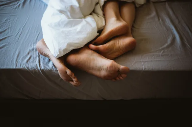 Pieds d'un couple au lit