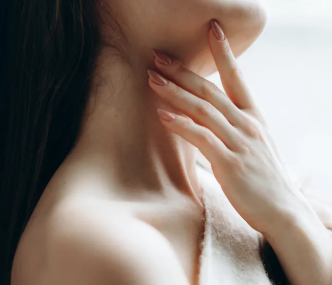 Une tendre femme méconnaissable appréciant la sérénité, portant élégamment un pull en laine tricoté doux avec une épaule nue