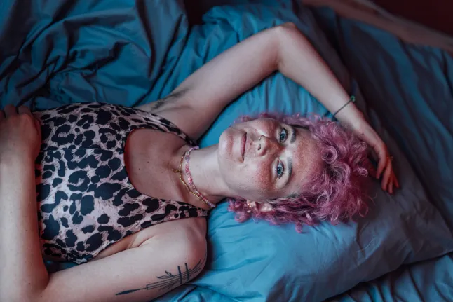 Portrait de femme couchée dans son lit à la maison
