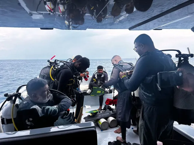 Cette image publiée par la Division des médias du président des Maldives montre des plongeurs se préparant à rechercher les quatre plongeurs italiens portés disparus près de l'île d'Alimathaa, sur l'atoll de Vaavu, aux Maldives, le samedi 15 mai 2026. (Division des médias du président des Maldives via AP)