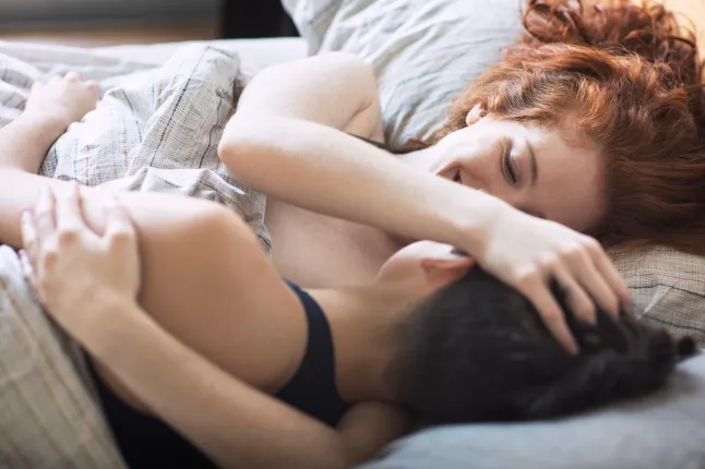 Vue grand angle d'un couple lesbien romantique sur le lit à la maison