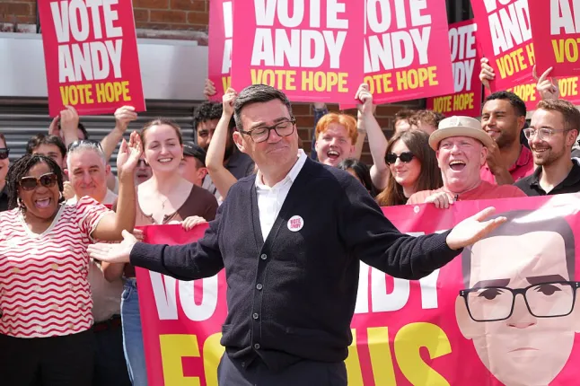 Le maire du Grand Manchester et candidat du Parti travailliste, Andy Burnham, salue ses partisans au siège de la campagne travailliste au Stubshaw Cross Community and Sports Club le 18 juin 2026 à Ashton-in-Makerfield, en Angleterre.