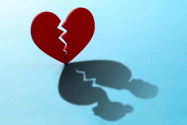 Coeur brisé. Fissure dans le coeur rouge, Rompre la relation. Ombre du cœur sous la forme de deux figures d'homme et de femme.; Numéro d'identification Shutterstock 1562200963