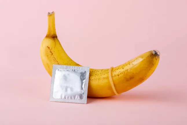Une banane à côté d’un préservatif pour indiquer des rapports sexuels protégés.