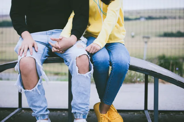 Jeune couple d'adolescents se tenant la main dans un parc public.