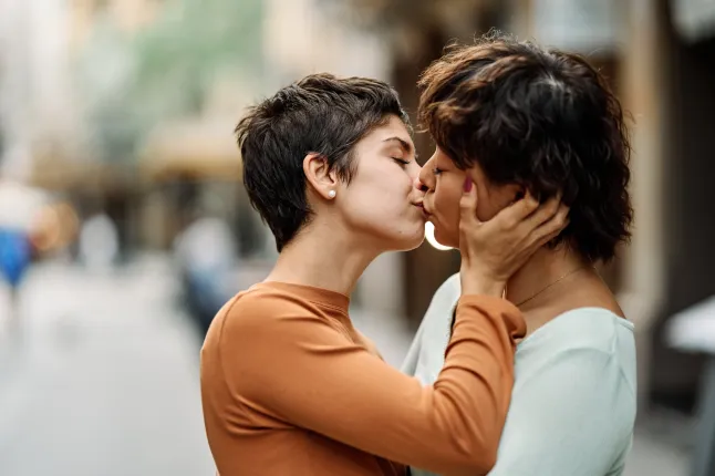 Scène romantique d'un couple lesbien s'embrassant tendrement dans la rue - concept LGBT