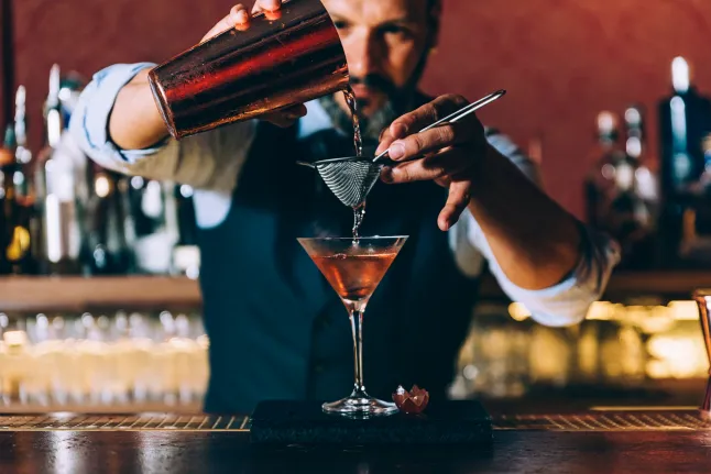 Un barman expert prépare un cocktail en boîte de nuit.