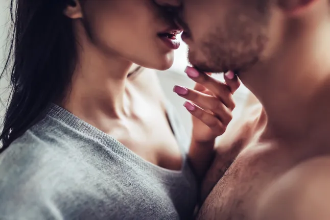 Gros plan d'un jeune couple romantique s'embrasse et profite de la compagnie l'un de l'autre à la maison.