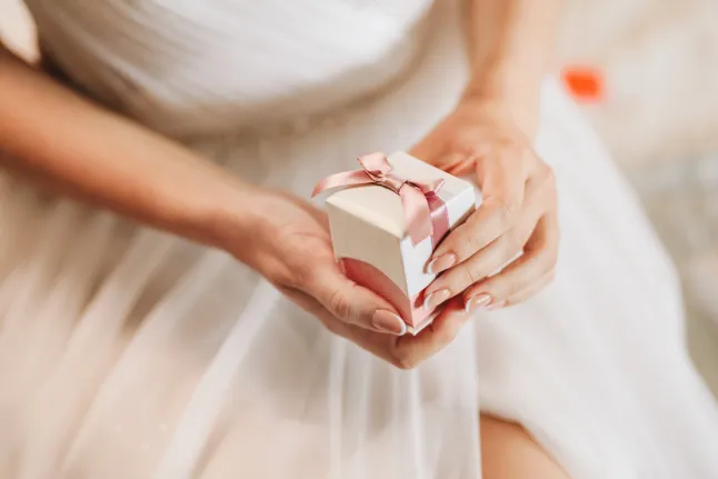 Mariée tenant une boîte avec des bijoux pour le jour de son mariage