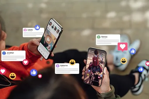 Deux mains féminines tenant leur smartphone, se connectant aux réseaux sociaux, laissant des commentaires, envoyant des messages et partageant des photos. La technologie connecte les gens.