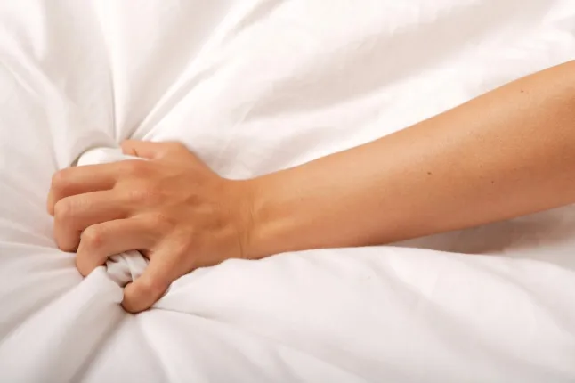 Main saisissante sur un drap blanc