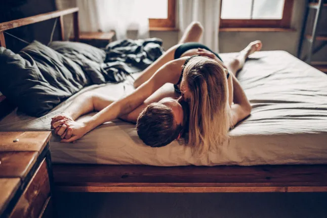 Couple romantique s'embrassant sur le lit - nu