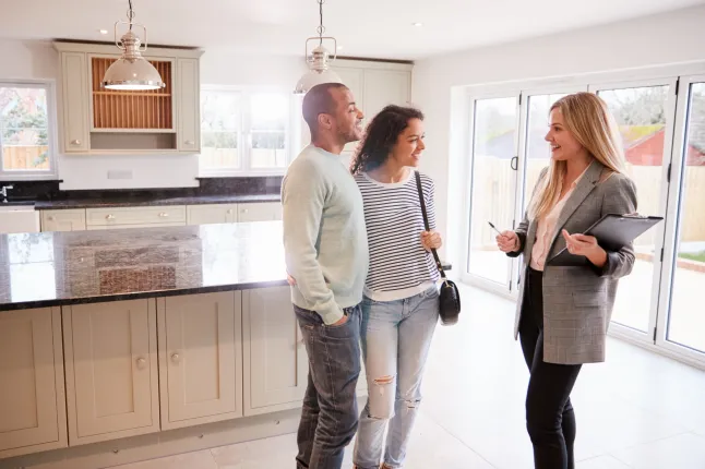 Agent immobilier féminin montrant un couple intéressé à acheter autour de la maison ; Numéro d'identification Shutterstock 1470587294 ; commande_achat : - ; emploi: -; client: -; autre: -