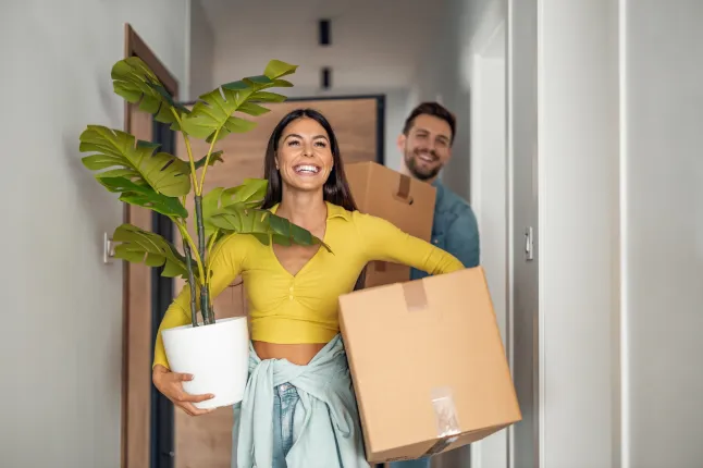 Jeune couple emménageant dans une nouvelle maison.Le couple s'amuse avec des boîtes en carton dans une nouvelle maison le jour du déménagement.; Numéro d'identification Shutterstock 2188934463 ; order_achat : - ; emploi: -; client: -; autre: -