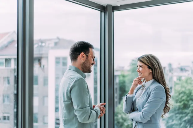 Plan de deux collègues discutant dans un bureau moderne. Des gens d'affaires confiants travaillant ensemble au bureau. Des hommes d'affaires discutant de nouveaux projets et partageant des idées sur le lieu de travail.