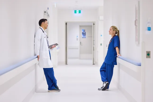 Médecins, hommes et femmes, parlant en s'appuyant sur une balustrade